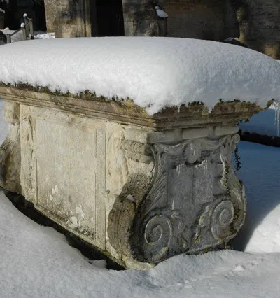 Chest tomb of Robert and Edward Briggs in St Mary's parish churchyard, Cowley, Gloucestershire, in snow