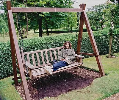 A seat in the Swinging Garden at Buscot Park Contrasting with the formality of most of Buscot Park is the circular Swinging Garden. Around it have been placed chain-suspended garden seats on which adults are welcome to sit and gently swing. A friend demonstrates how relaxing this can be.  For more details go to http://www.buscot-park.com/frameset3.html  and click on Woodland avenues.
